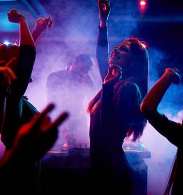 Group of dancing young people enjoying night in club